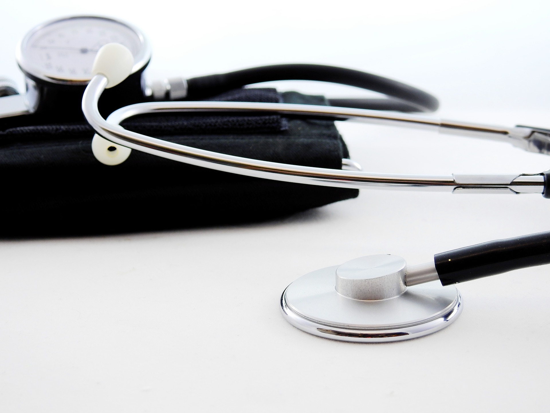 Blood pressure cuff and stethoscope on a white table.